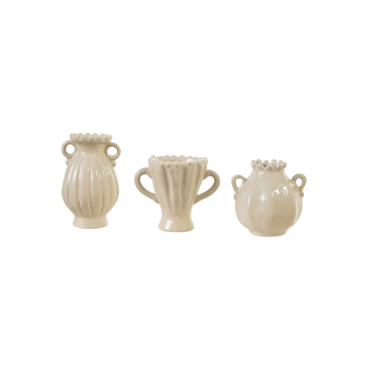 Three white ceramic vases of different shapes on a white background
