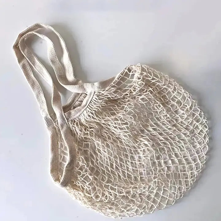 Beige mesh shopping bag with handles on a white background