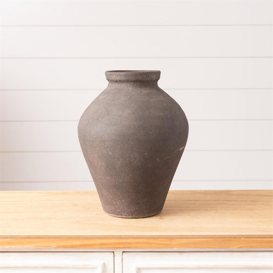 Brown ceramic vase on a wooden surface with a white background
