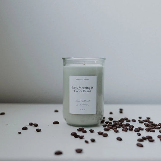 Candle labeled 'Early Morning Coffee Bean' with coffee beans on a white surface