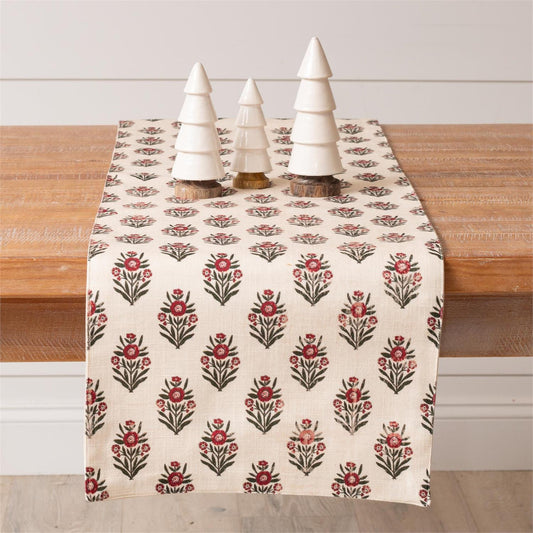 Floral patterned table runner on a wooden table with decorative trees.