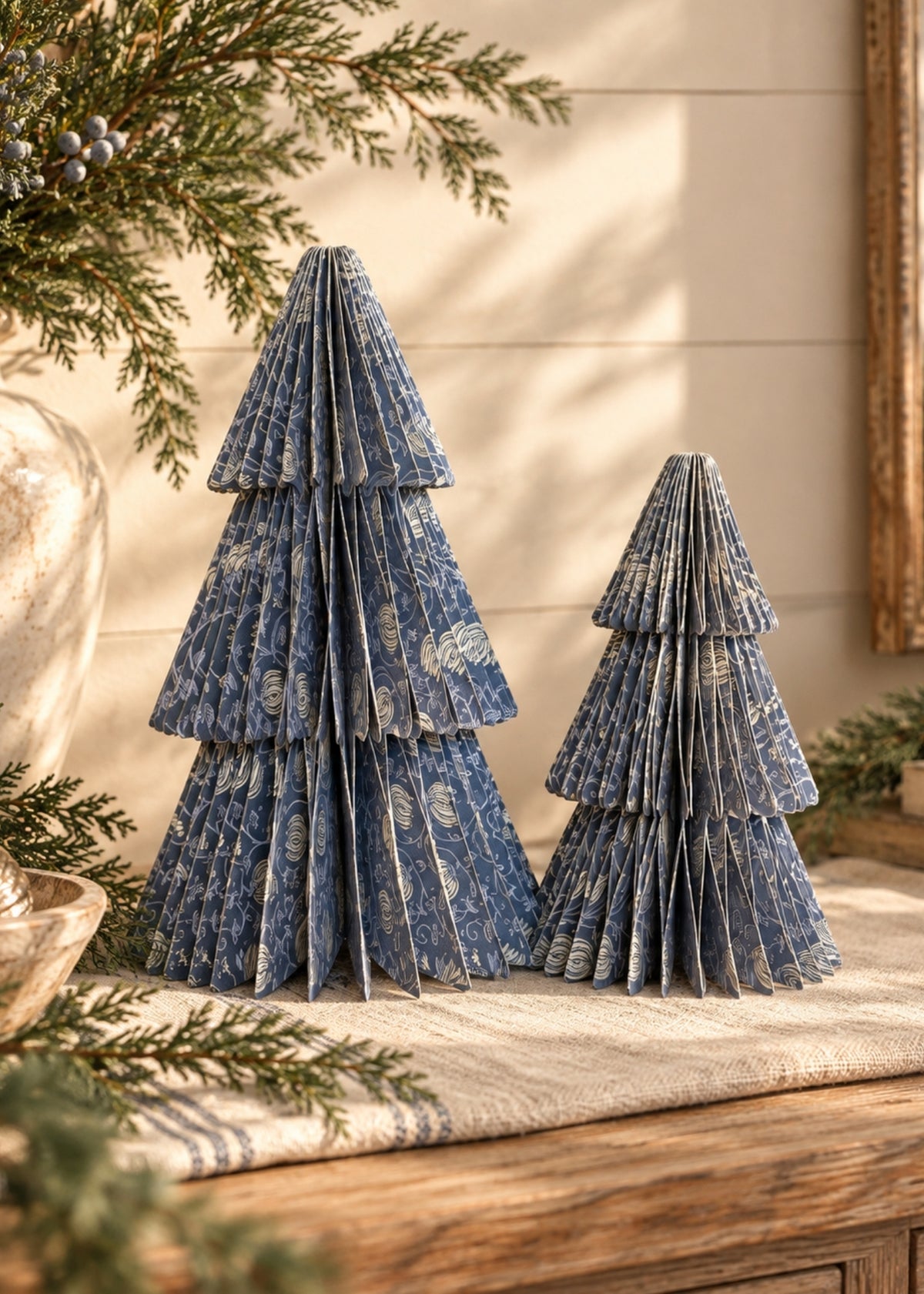 Bring seasonal charm to your home with this set of two handmade folding honeycomb trees, each featuring a beautifully patterned design in two complementary styles. Their lightweight, collapsible construction makes them easy to display, store, and reuse year after year. Perfect for tabletops, mantels, shelves, or holiday centerpieces, these decorative trees add a festive touch to any space. Pack comes with one small tree and one large tree. 

