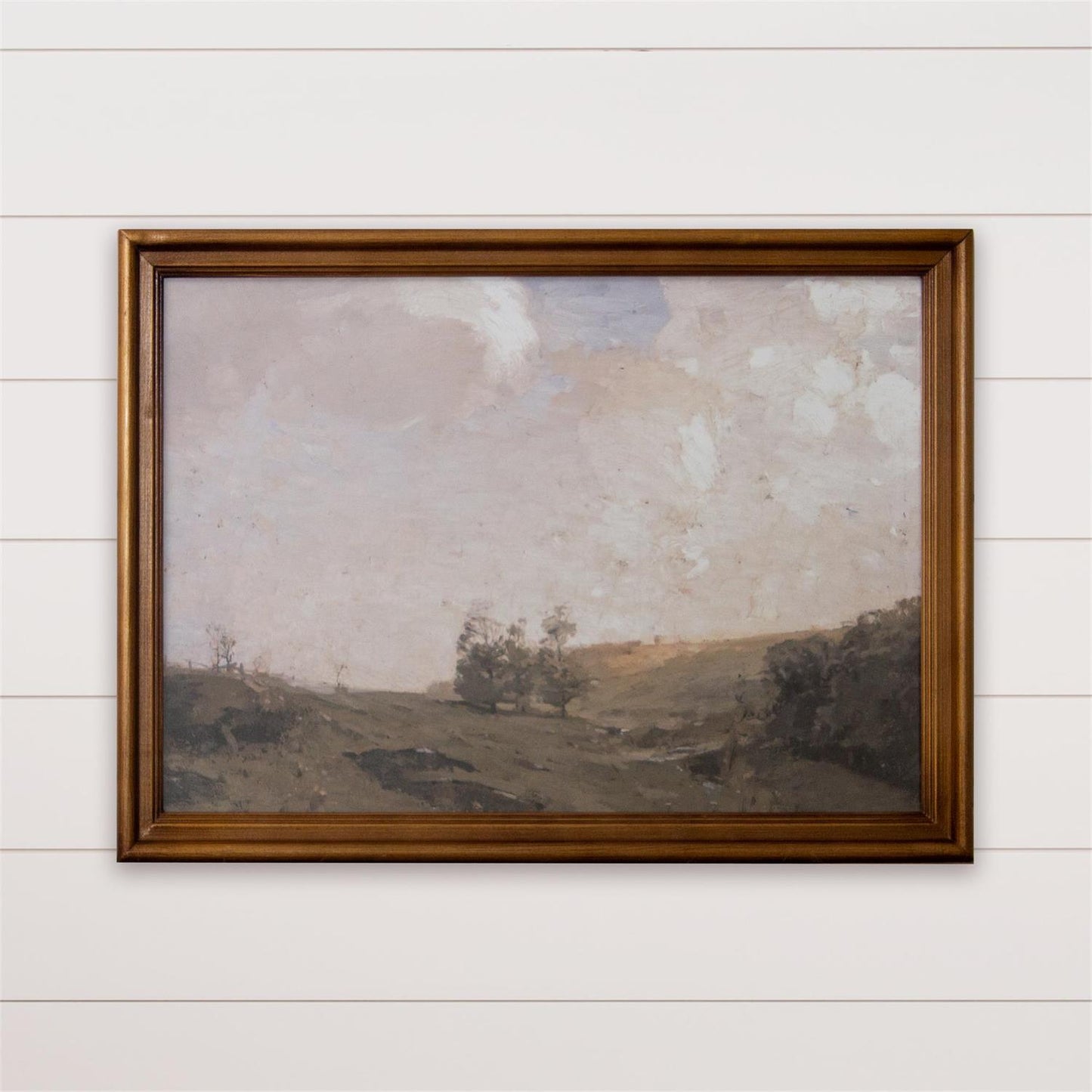 Framed landscape painting on a white wall