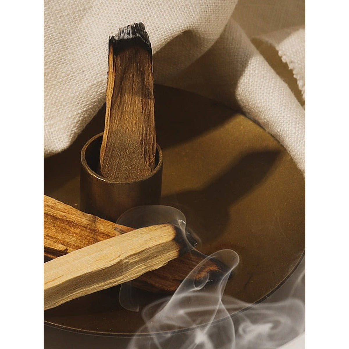 Incense sticks with smoke on a textured surface