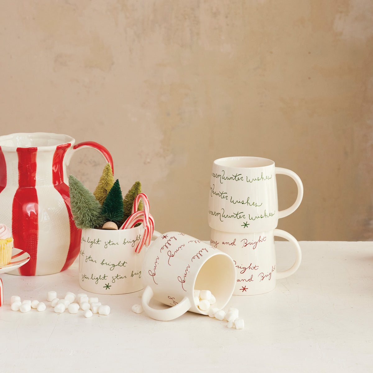 Set of Christmas-themed mugs with decorative elements on a neutral background