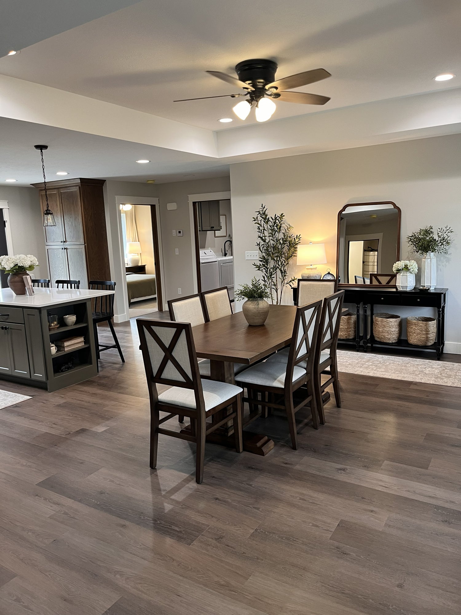 Dining room with wooden table and chairs, ceiling fan, and decorative elements.
