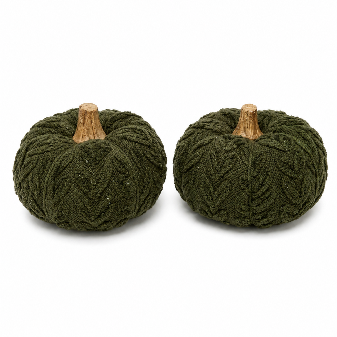 Two small decorative pumpkins made from dark olive green chunky knit fabric, each with a light brown faux-wood stem, shown on a plain white background.