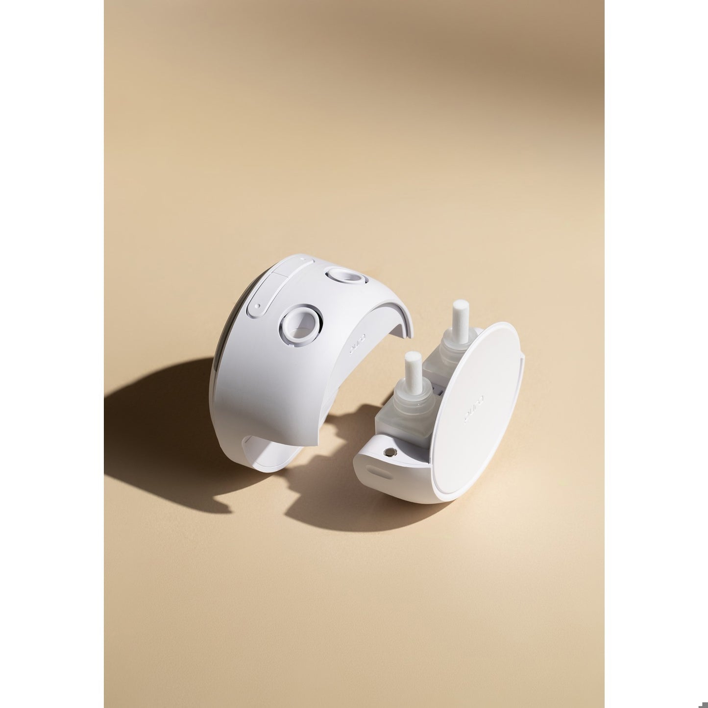 White electronic Pura fragrance device on a beige background