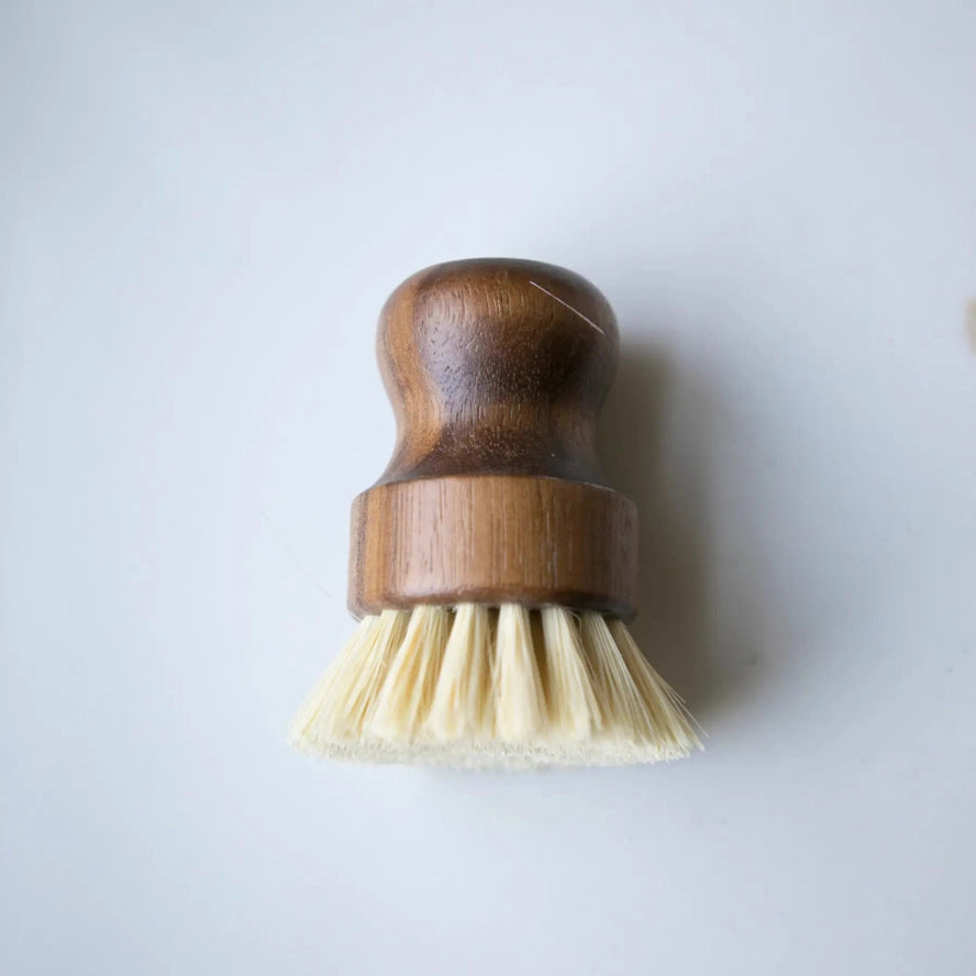 Wooden dish brush with bristle head on a light gray background