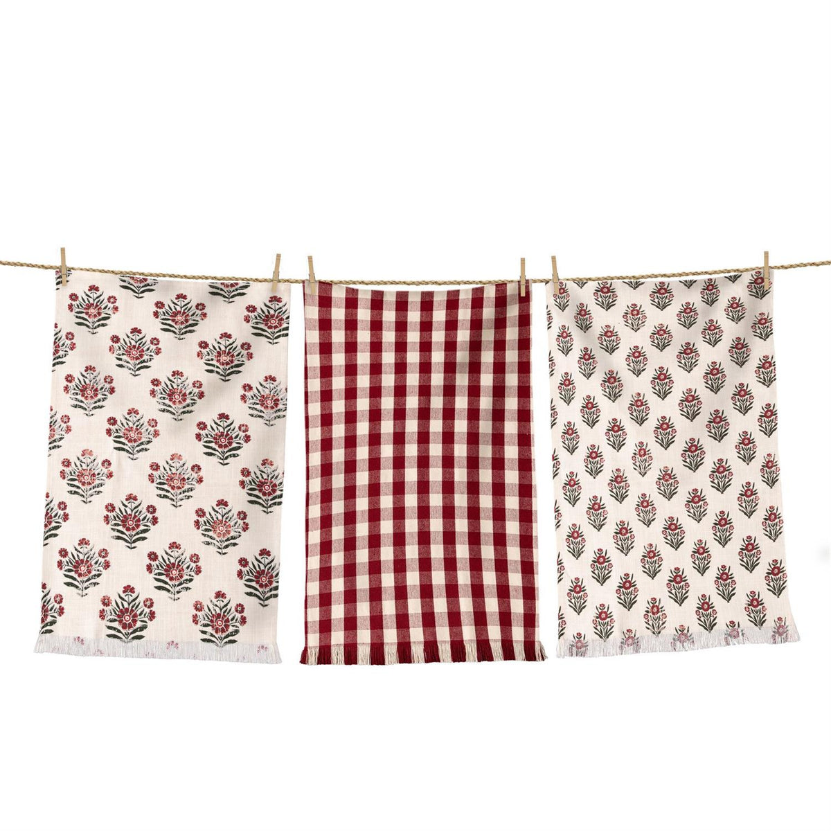 Three towels with floral and checkered patterns hanging on a line.